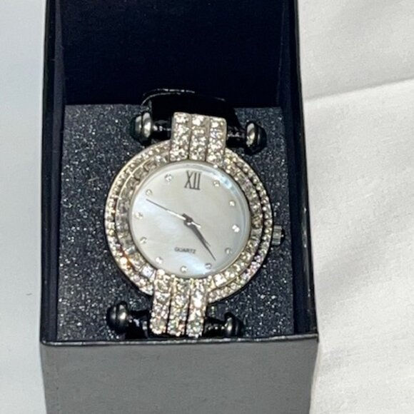 Elegant watch with black strap and decorative bezel.